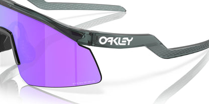 Oakley sunglasses with purple lens and black frame on a white background